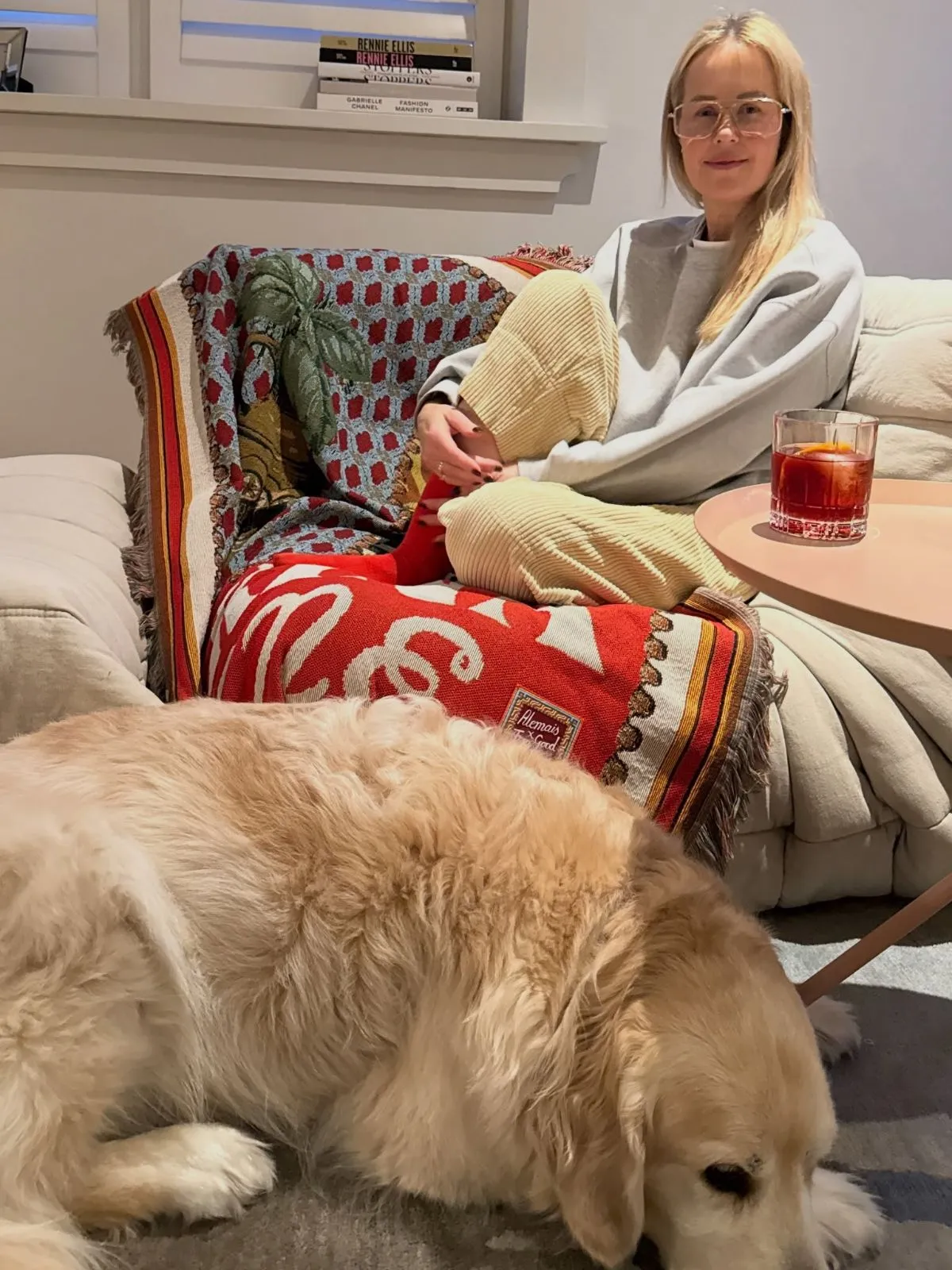 A compassionate foster guardian sitting quietly next to a rescue dog in a living room