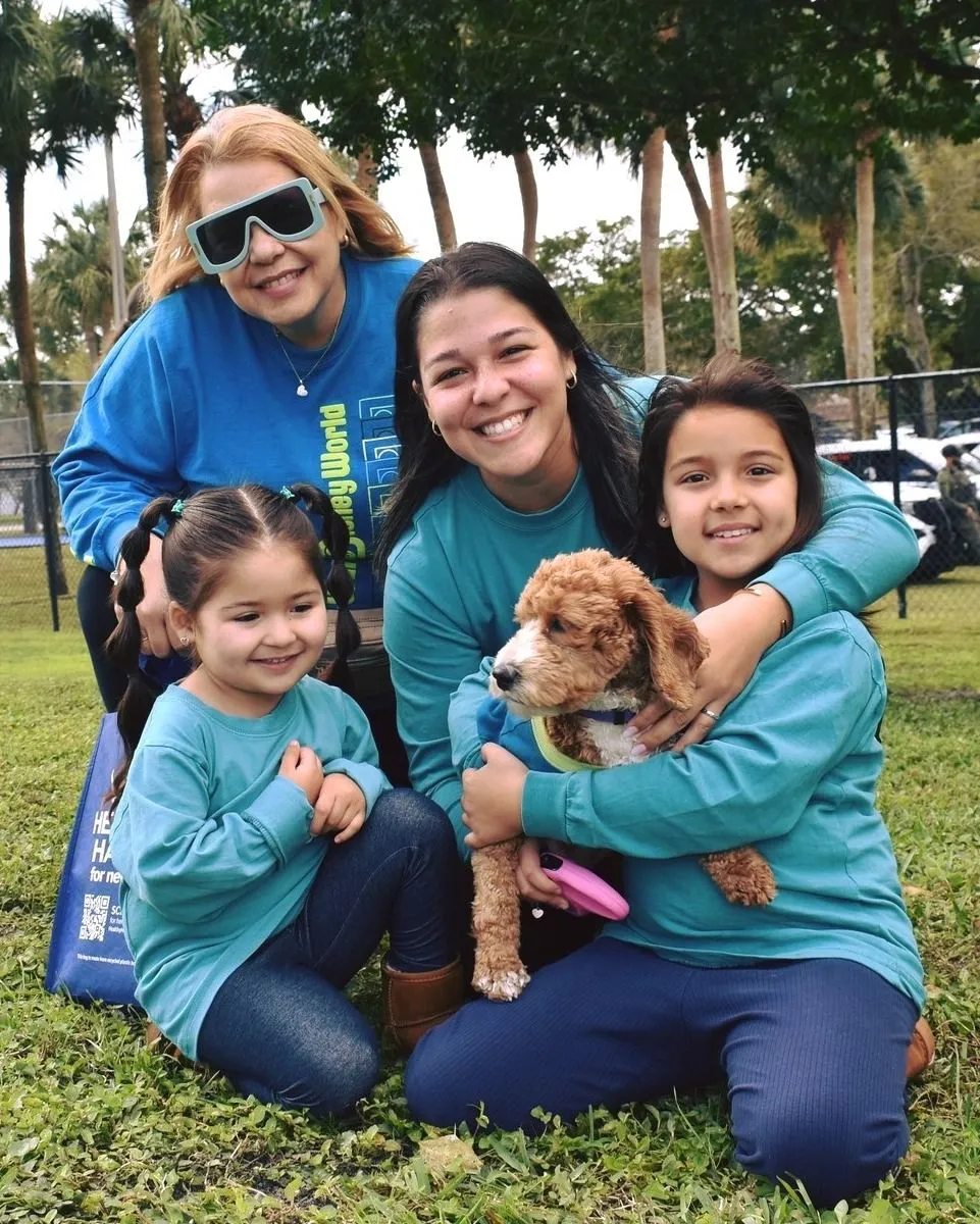 Volunteer With Rescue Dogs at Outdoor Events Volunteer standing next to a rescue dog at an outdoor animal shelter adoption event.