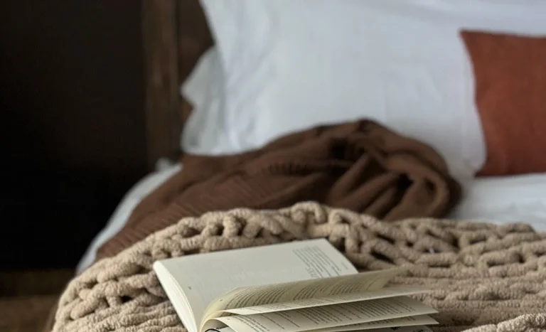A soft, cozy beige blanket in a warm, softly lit room, symbolizing comfort and remembrance after the loss of a foster kitten.